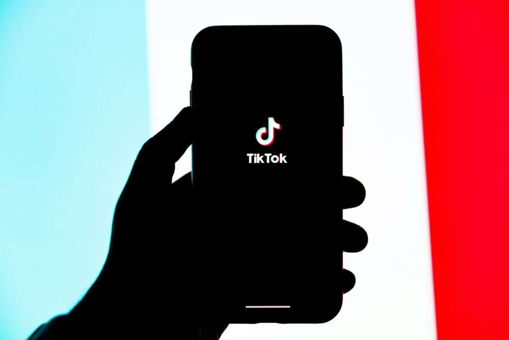 a person holding phone in his hand and showing the tiktok app