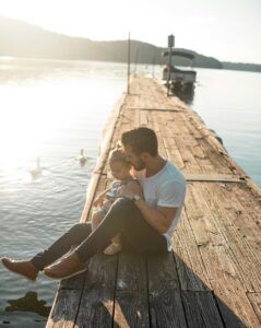 A man sitting with his kid on the sea shore