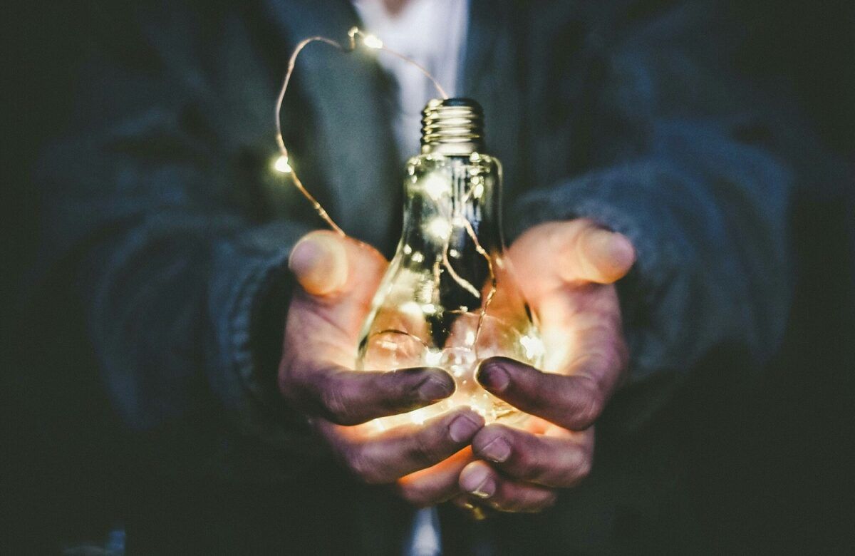 A man holding a light bulb, showing a concept of new business ideas